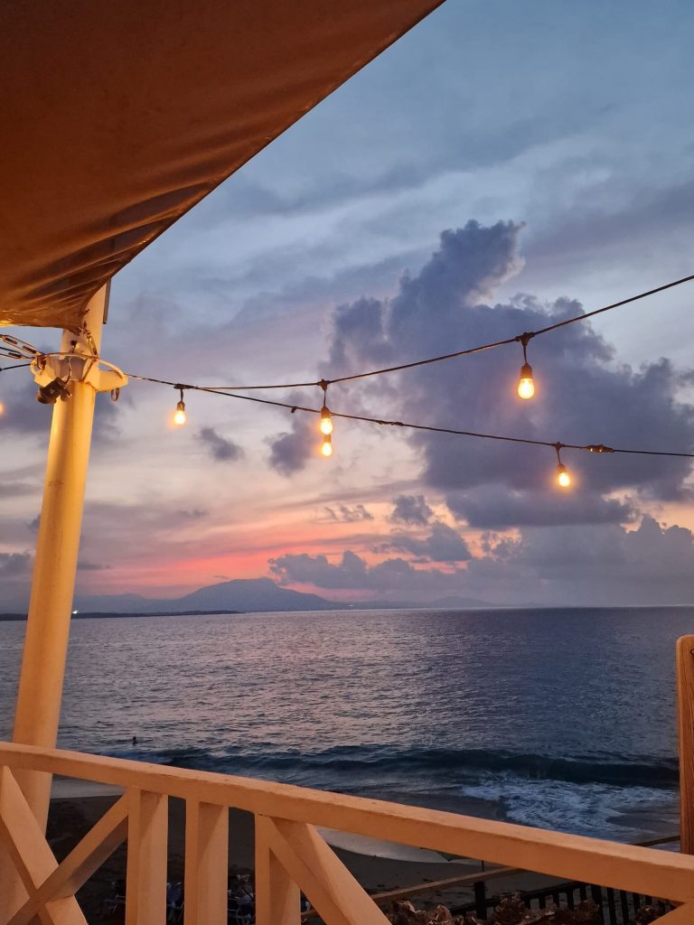 beachfront restaurant sunset string lights orange sky cabarete