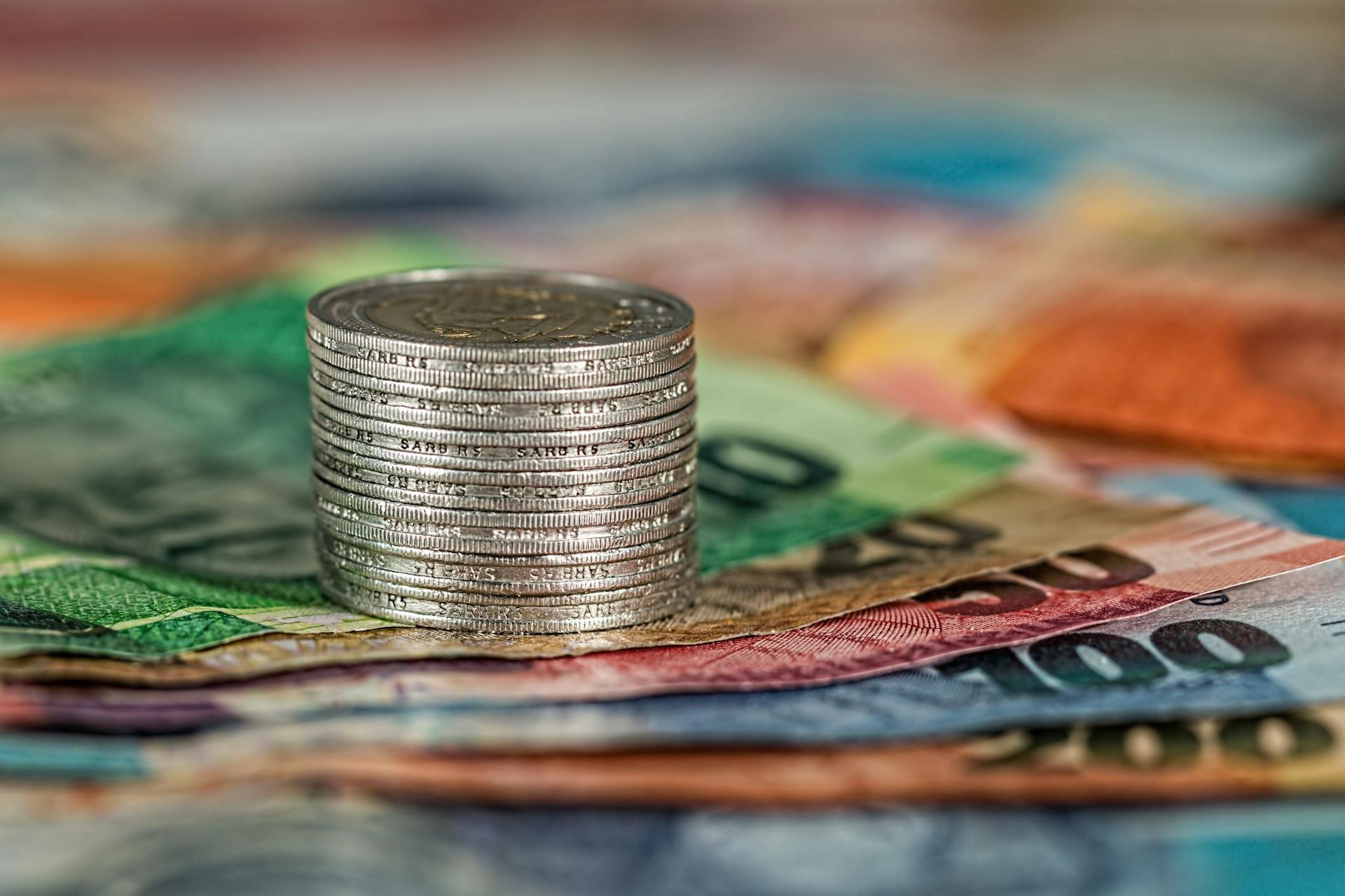 Coins stacked on banknotes representing taxes in the Dominican Republic
