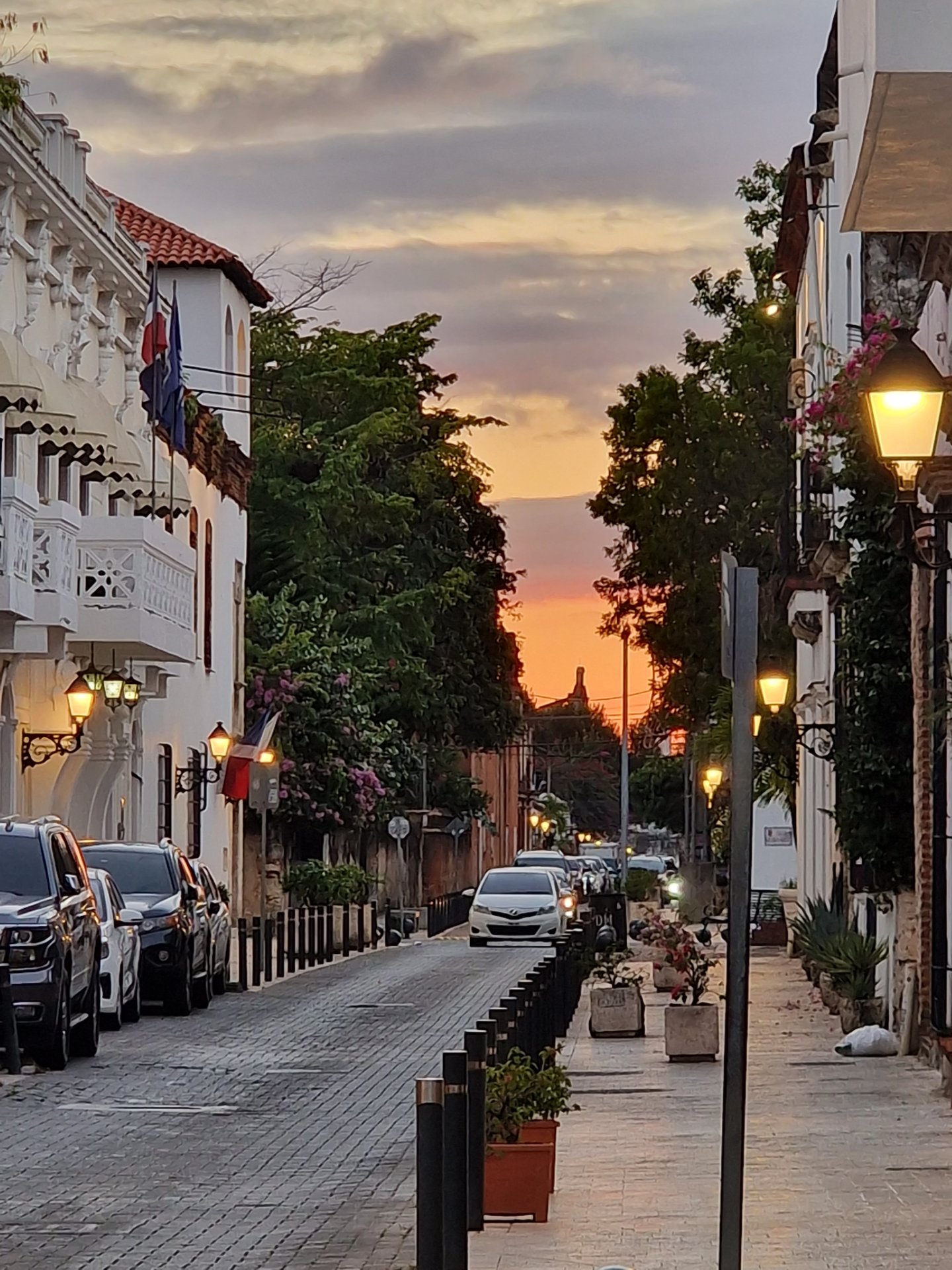 Colonial street at sunset with orange sky and balconies in Zona Colonial, Santo Domingo