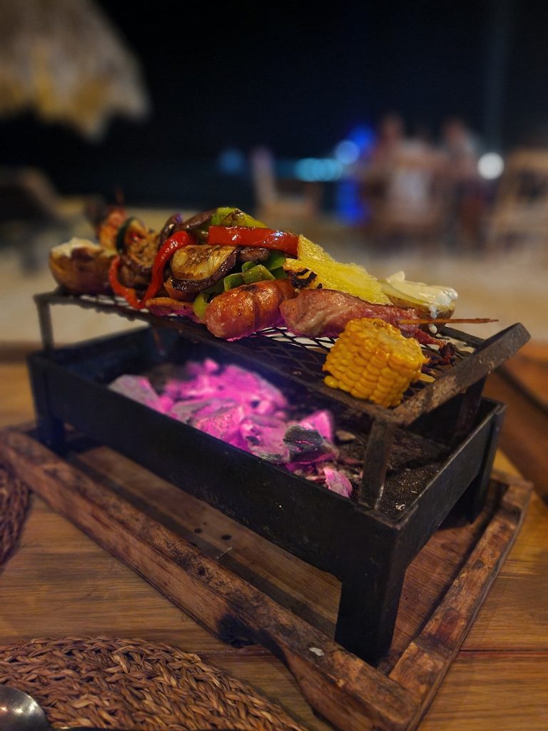 grilled meat skewer corn peppers glowing coals punta rucia lodge