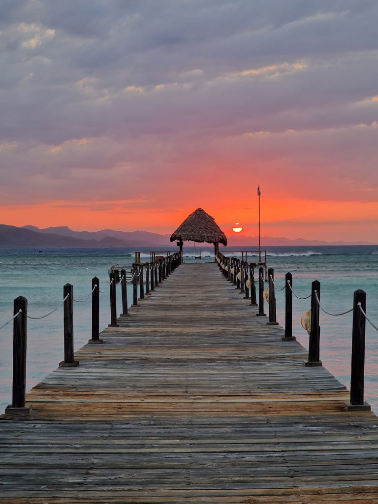 pier sunset orange horizon thatched palapa punta rucia lodge