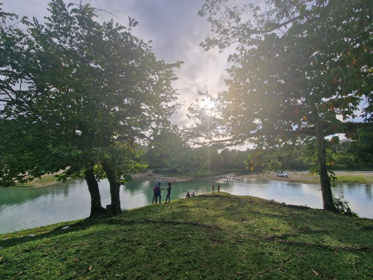 river bank trees green hills people bonao interior