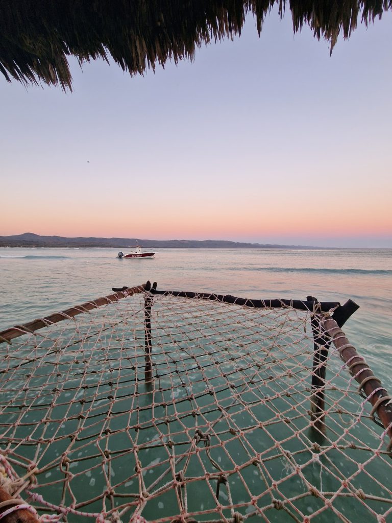 rope hammock turquoise sea dawn pink sky punta rucia lodge
