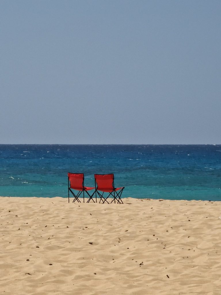 two red chairs white sand beach turquoise sea juan dolio