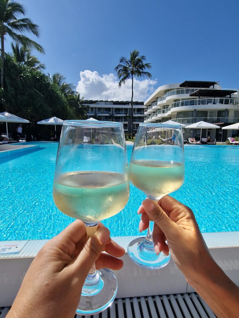 two white wine glasses toast resort pool palms las terrenas